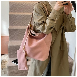 Pink hobo shoulder bag in frosted suede with matching coin purse shown on stairs