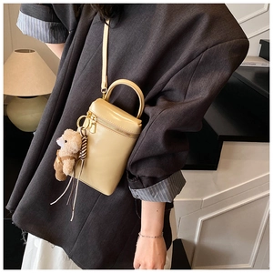 Détail du mini sac à bandoulière crème avec sangle amovible et charm ours mignon