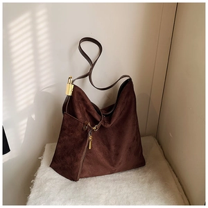 Detail of dark brown suede hobo bag with gold padlock and vertical decorative zipper