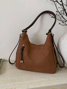 Caramel brown frosted suede hobo bag with fringe zipper detail and leather shoulder strap