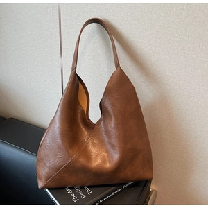 Close-up of brown PU leather hobo tote bag with diagonal stitching detail and soft texture
