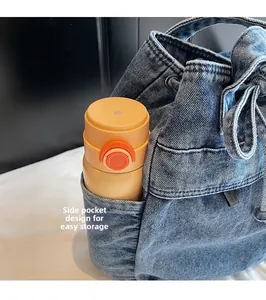 Detail view of denim bucket bag side pocket with a water bottle for storage display