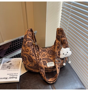 Detailansicht der Retro-Paisley-Segeltuchtasche mit Wolkenanhänger auf einem Leder-Ottomanen