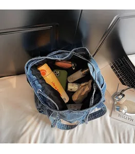 Top-down view of a spacious blue denim tote bag filled with daily essentials for work