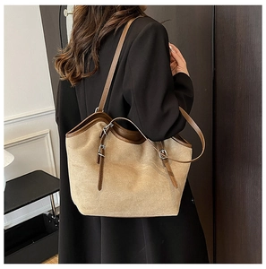 Detail of khaki tote bag featuring matte texture and adjustable brown leather straps