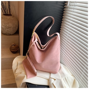 Pink frosted suede shoulder bag with matching pouch shown in elegant minimalist lighting