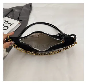 Vista superior del interior del bolso de gamuza negra con forro y bolsillo con cremallera