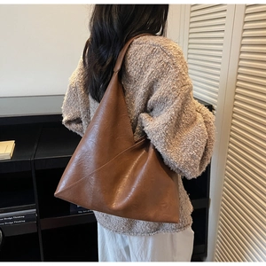 Brown leather tote bag styled with a beige sweater for a minimalist autumn look