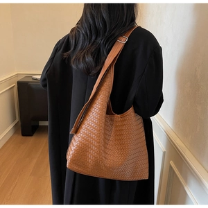 Détail du sac hobo marron tissé montrant la texture et la bandoulière sur un mannequin