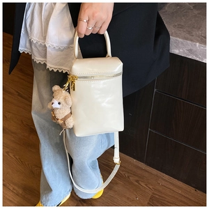 Détail du mini sac box blanc crème en cuir avec charme d'ours et bandoulière réglable