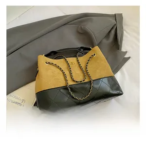 Detalle de bolso shopper bicolor en gamuza camello y cuero acolchado negro con cadena