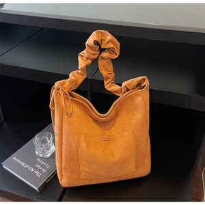 Detail of vintage caramel suede tote bag featuring ruched wide straps and side lace-up design