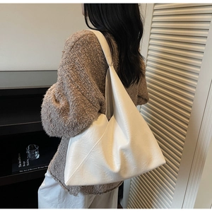 Minimalist beige PU leather tote bag with unique triangular cut and matte pleated texture