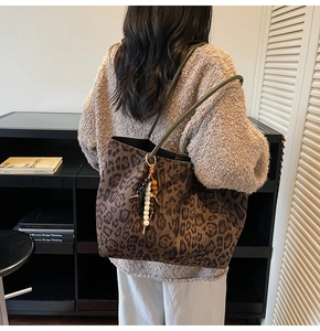 Détail du sac cabas en daim léopard avec anses vert foncé et breloque en perles