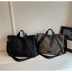 Detail von schwarzen und olivgrünen Nylon-Reisetaschen mit verstellbaren Schultergurten