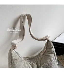 Detail of sage green crescent nylon shoulder bag featuring adjustable strap and side pocket