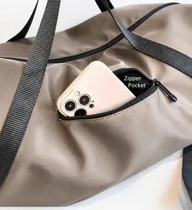 Détail de la poche latérale zippée du sac de voyage en nylon imperméable pour smartphone