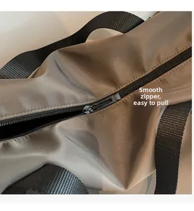 Détail de la fermeture éclair fluide et de la sangle en nylon du sac de voyage