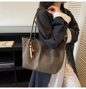 Détail du grand sac cabas en suédine avec breloque en perles de bois en vert-marron rétro