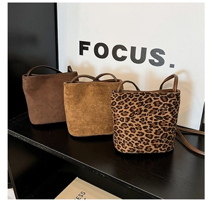 Detail view of vintage bucket bags in dark brown, camel suede, and leopard print options