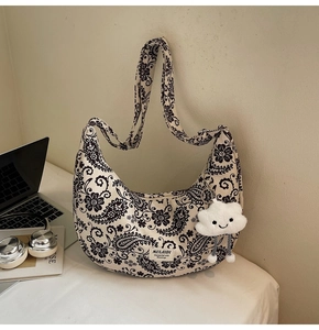 Detail der Vintage Hobo-Umhängetasche mit Paisleymuster und Plüsch-Wolkenanhänger