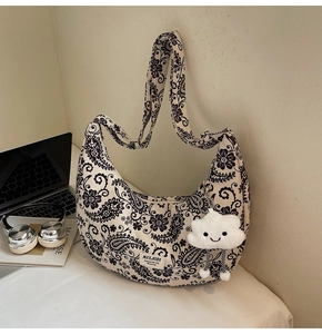 Detail der Retro-Tasche mit Paisley-Muster und niedlichem Plüsch-Wolkenanhänger