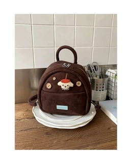 Detail of vintage brown suede mini backpack with cute cartoon dog and wooden buttons decoration