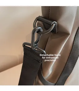 Detailansicht des abnehmbaren schwarzen Metallhakens und Trageriemens der Reisetasche