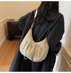 Detail view of khaki nylon crescent crossbody bag with drawstring design and side pockets