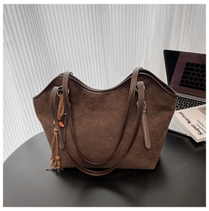 Detail of dark brown matte tote bag featuring beaded tassels and suede texture