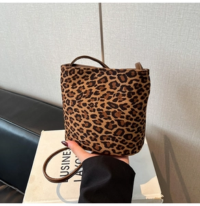 Detail view of mini leopard print bucket bag made of premium suede material and thin strap