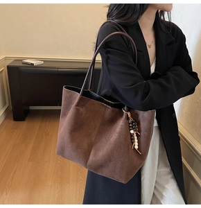 Détail du grand sac cabas en daim marron foncé avec pompon perlé de style bohème