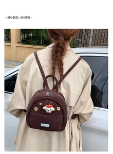 Detail of dark brown corduroy mini backpack with 3D puppy applique and wood buttons
