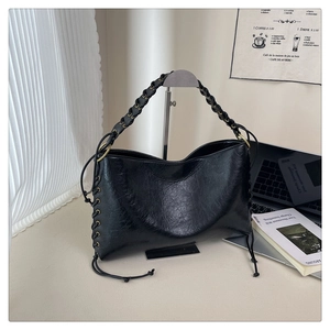 Détail de la poignée tressée et de l'anneau doré sur ce sac à bandoulière noir vintage