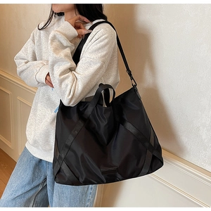 Detailansicht der schwarzen Nylon-Reisetasche mit robustem Stoff und Umhängeriemen