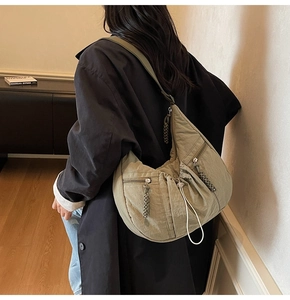 Detail view of large olive green crossbody bag with pleated nylon and drawstring closure