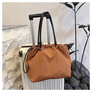 Caramel nylon drawstring tote bag side view showing spacious design and slim straps