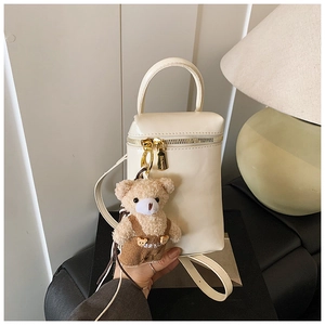 Détail du mini sac barillet blanc crème avec zips dorés et pendentif ourson mignon