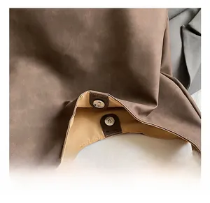 Close-up of magnetic metal closure and stitch detail on vintage brown leather tote bag