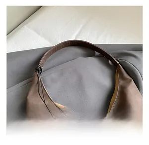 Detail of vintage brown suede shoulder bag with leather handle and leopard print tag