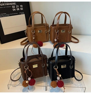 Detail showing four colors of faux suede tote bags with decorative wood bead charms