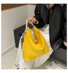 Macro detail of leopard bucket bag showing yellow velvet texture and white embroidery