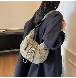 Detail view of army green pleated nylon crossbody bag showing texture and zippers