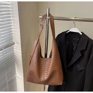 Détail du sac hobo montrant la texture en cuir tressé marron et la bandoulière
