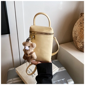 Détail du mini sac boîte jaune crème avec pendentif ours en peluche et zip doré chic