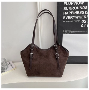 Detailed macro view of deep brown suede tote bag with adjustable silver buckle straps