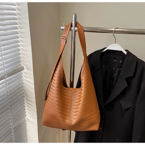 Détail d'un sac hobo en cuir tressé caramel avec bandoulière réglable et boucle en métal