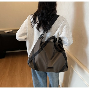 Reisetasche aus braunem Nylon in der Rückansicht zur Darstellung von Kapazität und Passform