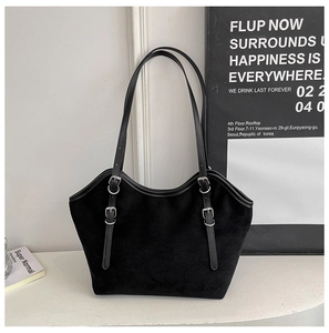 Close-up of black suede tote bag with adjustable silver buckle straps and matte texture