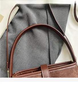 Detailed close-up of brown frosted leather bucket bag with diamond quilted stitching and strap